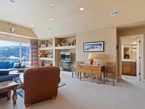 Living area with lofted ceiling, visible vents, light carpet, and recessed lighting