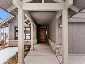 Doorway to property with a garage and stone siding