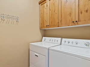 Laundry room with washing machine and clothes dryer and cabinet space