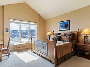 Bedroom with carpet, visible vents, vaulted ceiling, and baseboards