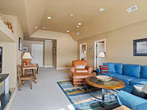 Living room with carpet floors, recessed lighting, visible vents, vaulted ceiling, and baseboards