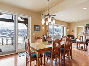 Dining space with a notable chandelier, light wood-style flooring, a mountain view, and recessed lighting