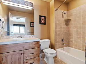 Full bath featuring toilet, bathtub / shower combination, vanity, and tile patterned floors