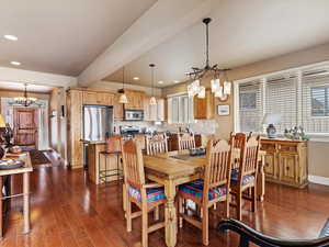 Dining space featuring dark wood-style floors, recessed lighting, a notable chandelier, and baseboards