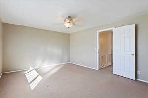 Unfurnished room with carpet floors, ceiling fan, and baseboards