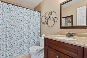 Full bathroom featuring toilet, tile patterned flooring, a shower with shower curtain, and vanity