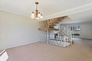 Interior space featuring stairs, ornamental molding, carpet flooring, and baseboards