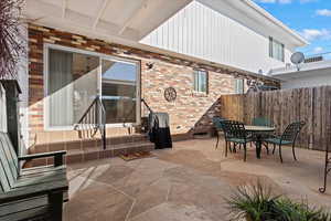 View of patio with entry steps, fence, and outdoor dining area