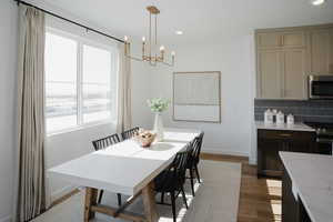 Dining room featuring a notable chandelier, baseboards, wood finished floors, and recessed lighting