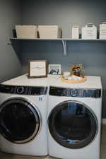 Washroom with laundry area and washer and clothes dryer