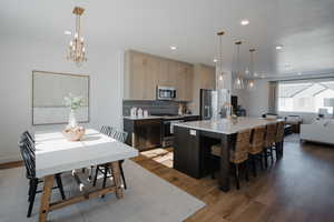 Kitchen featuring stainless steel appliances, light wood-style floors, a sink, and tasteful backsplash