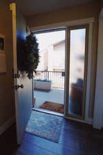 Doorway with hardwood / wood-style floors, a wealth of natural light, and baseboards