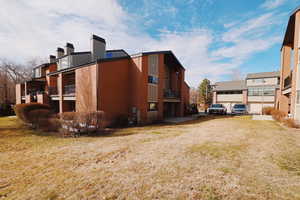 View of home's exterior featuring a residential view, a lawn, and brick siding