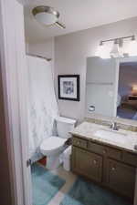 Full bathroom with toilet, a shower with curtain, and vanity