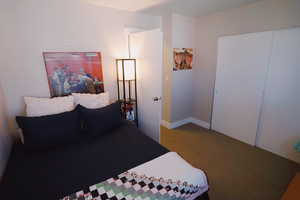 Bedroom featuring a closet, carpet flooring, and baseboards