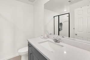 Bathroom featuring toilet, vanity, large shower
