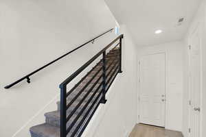 Stairway featuring foyer, door to garage and coat closet