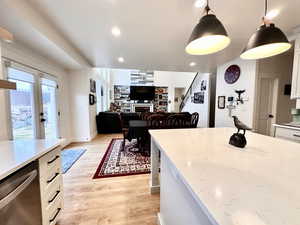 Kitchen with white cabinetry, recessed lighting, a fireplace, dishwasher, and light wood-type flooring