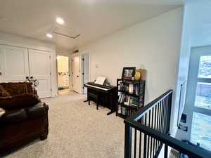 Living area featuring visible vents, an upstairs landing, recessed lighting, light colored carpet, and attic access