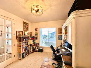 Office area with a chandelier, a textured ceiling, and carpet