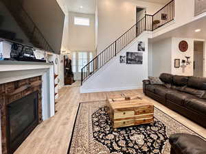 Living area with plenty of natural light, stairs, baseboards, and wood finished floors