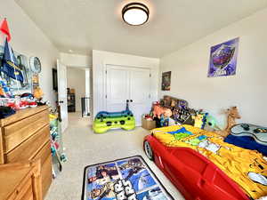 Bedroom featuring a closet, a textured ceiling, and carpet flooring