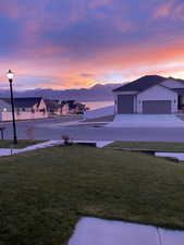 View of yard with a garage, fence, and a water and mountain view