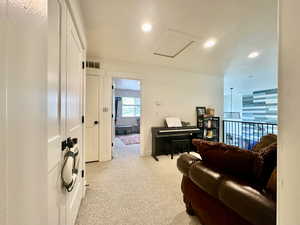 Living area featuring recessed lighting, visible vents, light carpet, and attic access