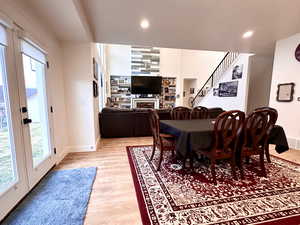 Dining area with baseboards, stairway, recessed lighting, light wood-style flooring, and a fireplace