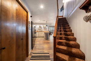 Stairway featuring wood finished floors and recessed lighting