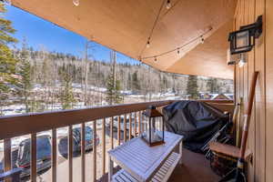 Snow covered back of property with area for grilling