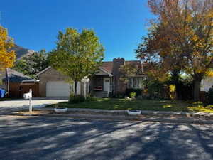View of front of property with an attached garage, driveway, and a front lawn