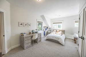 Carpeted bedroom with a textured ceiling and baseboards