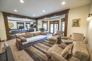 Living room with a textured ceiling, recessed lighting, baseboards, french doors, and carpet