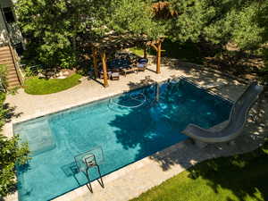 Pool featuring a water slide, a patio area, and a pergola