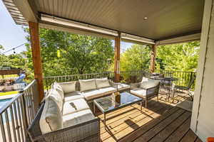 Wooden deck with an outdoor living space and a fenced in pool