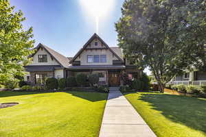 View of front of house featuring a standing seam roof, metal roof, a front lawn, and fence