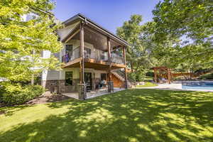 Rear view of property featuring a patio, brick siding, a yard, stairway, and a pergola