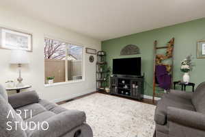 Living area with wood finished floors, visible vents, and baseboards