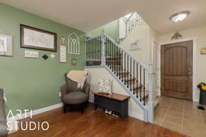 Foyer entrance featuring stairs and wood finished floors