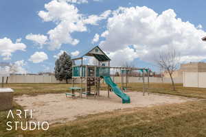 Community jungle gym with a yard and fence