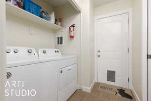 Laundry area featuring washing machine and dryer, visible vents, baseboards, and light tile patterned floors