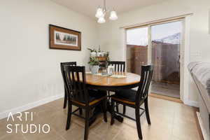 Dining room featuring a chandelier, light tile patterned floors, and baseboards