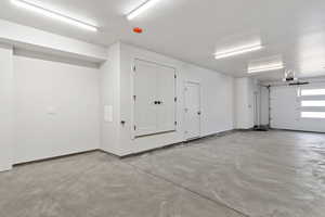 Garage featuring a garage door opener and baseboards