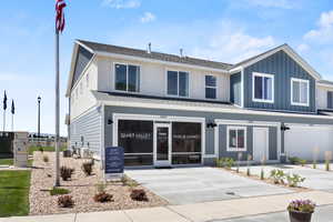 View of front of home with a garage, concrete driveway, a shingled roof, and board and batten siding