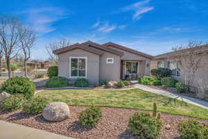 View of front of house with a front yard and stucco siding