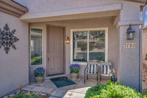 Property entrance with covered porch and stucco siding