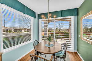 Dining space featuring a chandelier, baseboards, and wood finished floors