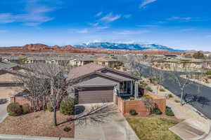 Ranch-style home with an attached garage, driveway, fence, and a mountain view