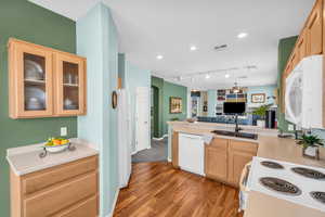 Kitchen with white appliances, a sink, visible vents, open floor plan, and light countertops